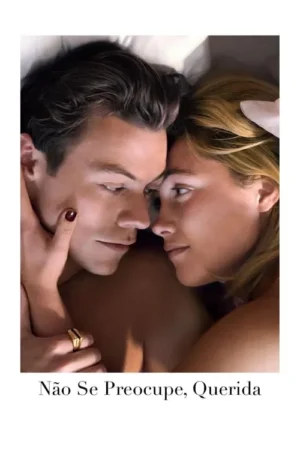 Close-up de um casal jovem em um abraço íntimo na cama, rostos próximos e olhares fixos. A mão dela acaricia o rosto dele.