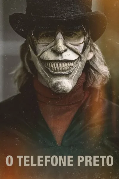 Um homem de cartola e óculos, com olhos visíveis e máscara branca de sorriso medonho. Cabelo comprido, fundo sombrio.