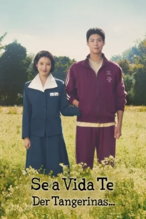 Uma mulher e um homem jovens sorriem em um campo florido. Ela usa uniforme azul, ele um agasalho vinho. Clima sereno e campestre.