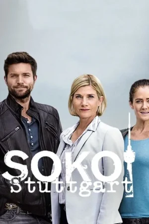 Um homem barbudo de jaqueta escura e duas mulheres, uma de blazer claro, posam à frente de um fundo urbano suave e céu cinzento. Clima profissional.