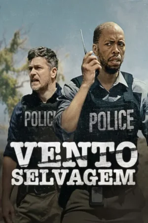 Dois policiais em coletes à prova de balas, um com walkie-talkie, com expressões de alerta em campo aberto.