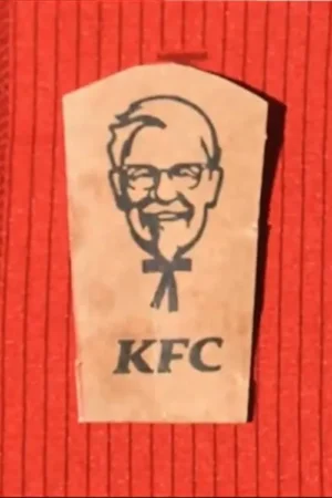 Recorte em forma de lápide marrom com desenho de homem sorridente de óculos, gravata borboleta e o logo KFC, sobre fundo vermelho.