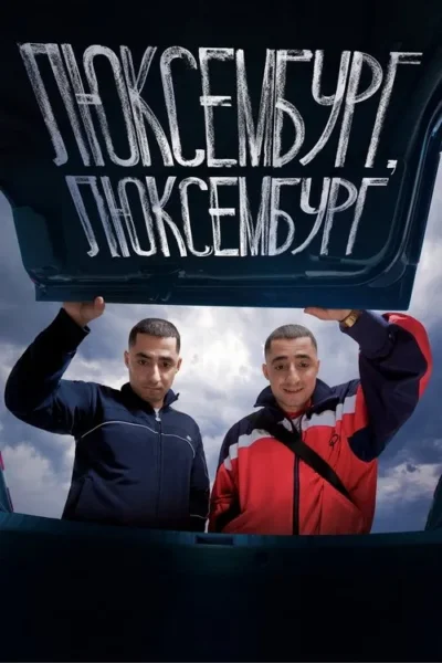 Dois homens seguram a tampa de um porta-malas de carro. Um está sério de azul, o outro sorri de vermelho, sob um céu cinzento.