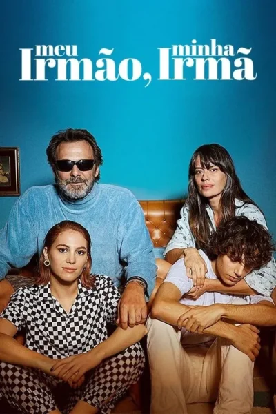 Quatro pessoas posam em sala azul. Homem de óculos, mulher de xadrez no chão. Outra mulher abraça jovem deitado em seu colo.