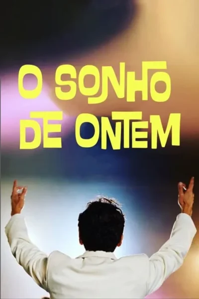 Uma figura em paletó branco, de costas, braços erguidos em celebração. Fundo vibrante e borrado com luzes de palco.