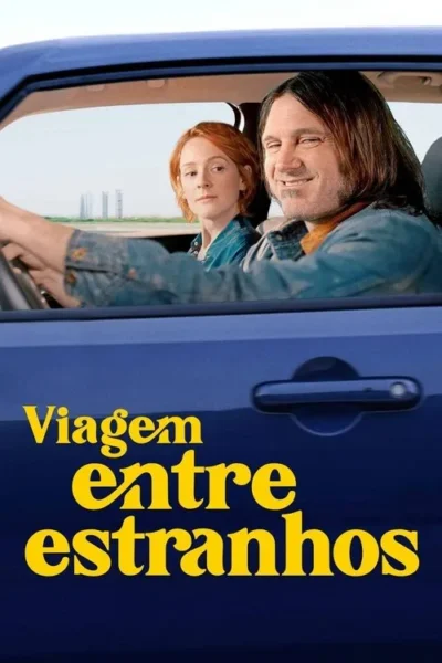 Homem de cabelo longo sorrindo e mulher ruiva séria em carro azul. Dirigem por estrada aberta sob céu claro. Clima de road trip.