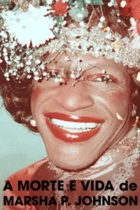 A Morte e Vida de Marsha P. Johnson 5 Pessoa de pele escura sorri amplamente, usando maquiagem vibrante e uma touca com flores e brilhos. Fundo claro. Retrato alegre e marcante.
