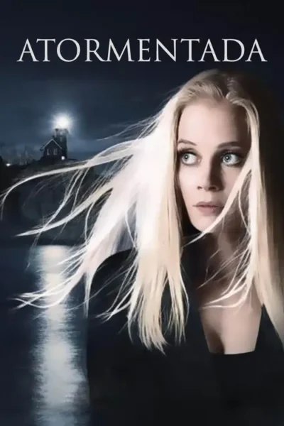 Mulher loira com cabelo esvoaçante olha assustada. Farol em penhasco ilumina mar escuro e agitado. Clima de suspense.