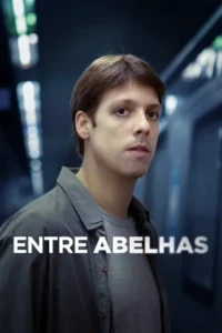 Homem jovem, cabelo castanho e olhar sério, em primeiro plano. Fundo urbano desfocado com luzes azuis. Clima pensativo.