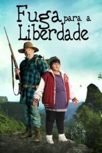 Homem barbudo com rifle e menino de jaqueta vermelha, em cima de montanha verde. Helicópteros no céu azul sugerem perseguição.