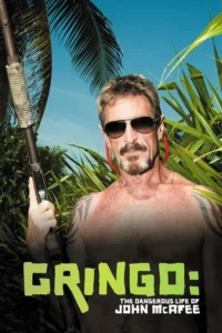 Gringo: The Dangerous Life of John McAfee 2 Homem barbudo, óculos escuros, sem camisa e com tatuagens, segurando uma espingarda, em cenário tropical com céu azul. Clima tenso.