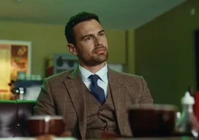 Homem de terno tweed olha pensativo em café com iluminação verde. Atmosfera intrigante.