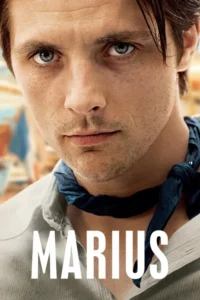 Homem com olhos azuis intensos,barba rala e lenço azul no pescoço,olhando fixamente. Fundo desfocado com tons quentes.