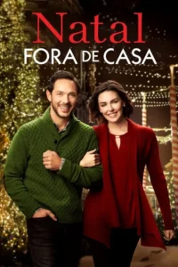 Casal sorridente em cenário natalino noturno. Ele de suéter verde,ela de vermelho. Fundo iluminado por luzes cintilantes e árvores.