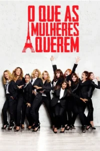 Grupo de mulheres em ternos pretos posa de forma animada e divertida contra uma parede clara. O clima é vibrante e cômico.