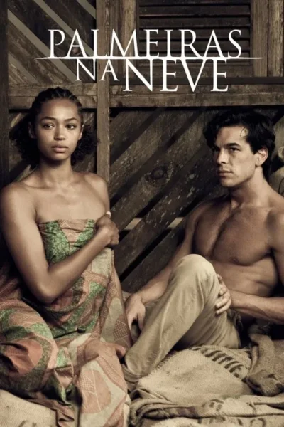 Jovem mulher em tecido estampado e homem sem camisa sentados em sacos de estopa, fundo de madeira. Ambos têm olhar sério.