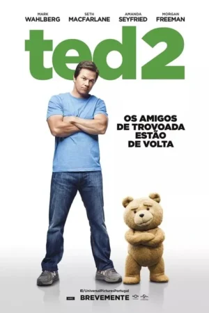 Homem sério de camisa azul e jeans e um urso de pelúcia fofo, ambos de braços cruzados, em fundo branco.