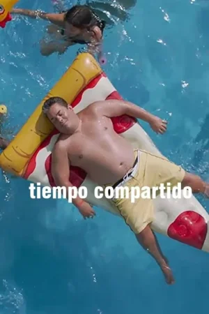 Homem corpulento deitado em flutuador de pizza na piscina. Uma pessoa nada ao fundo. Clima de verão descontraído e cômico.
