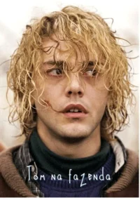 Close-up de homem loiro de cabelo bagunçado,com um corte no rosto e olhos avermelhados. Seu olhar é tenso e apreensivo.