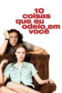 Um jovem de cabelo longo e uma mulher de blusa florida,ambos com expressões sérias,posam em uma poltrona marrom contra fundo branco.