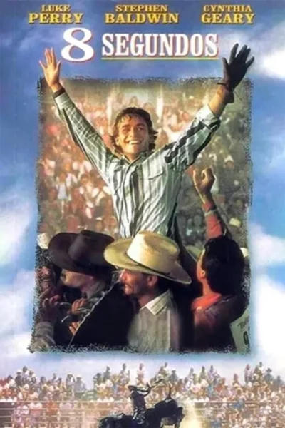 Homem sorridente celebra com braços erguidos em vitória num rodeio. Multidão aplaude, cowboys assistem e um peão monta um touro.