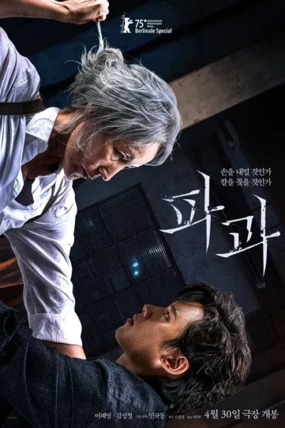 Mulher idosa de cabelos grisalhos olha intensamente para homem deitado, segurando ferramenta pontiaguda sobre ele. Cenário escuro, tenso.