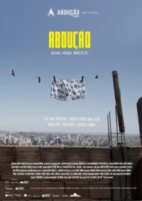 Uma cueca com caveiras em um varal sobre telhado, com vista da cidade sob céu azul. Atmosfera urbana e peculiar.