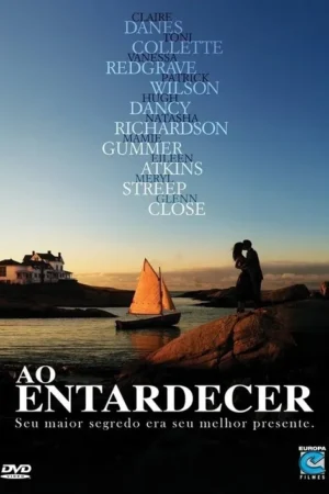 Pôster: Casal se abraça silhuetado em rocha ao pôr do sol, com veleiro e casa à beira-mar. Clima romântico e sereno.