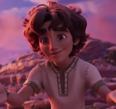 Jovem garoto animado de sorriso caloroso e mãos abertas em deserto rochoso com céu rosa-púrpura ao entardecer.