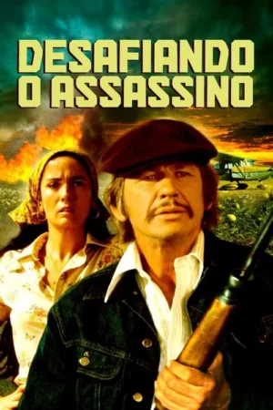 Homem sério de boina e rifle, com mulher assustada atrás. Cenário de ação com fogo, fumaça e avião ao pôr do sol.