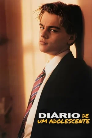 Adolescente de cabelo claro, terno e gravata listrada, com olhar sério e intenso, encostado em parede iluminada. Tom quente.