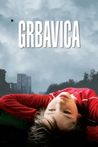 Rosto de jovem de blusa vermelha,invertido,olhando para cima,contra céu cinzento e silhuetas de prédios. Clima melancólico.