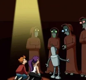 Três personagens (2 humanos, 1 robô) observam cinco figuras alienígenas encapuzadas em um palco escuro. Um feixe de luz foca uma das figuras.