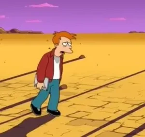 Um homem ruivo e cansado caminha por um deserto amarelo rachado sob um céu roxo. Há linhas escuras no chão e colinas distantes.