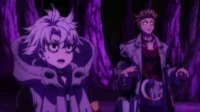 Duas figuras em um ambiente sombrio e roxo. Uma jovem com capuz tem olhos arregalados de choque, enquanto um homem de olhos brilhantes mantém uma postura séria.