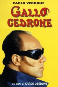 Homem de óculos goggle escuros e costeletas,em perfil contra fundo amarelo brilhante. Um visual peculiar e chamativo.