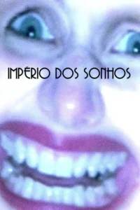 Close-up embaçado de um rosto surreal com olhos azuis arregalados e um sorriso largo de lábios roxos. Predominam tons de azul e roxo.