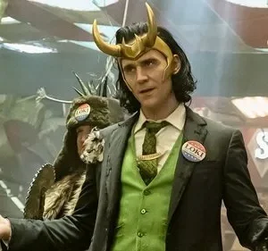 Homem de elmo dourado c/ chifres, terno verde e botão político, gesticula. Figuras excêntricas no fundo caótico.