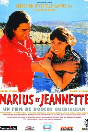 Um casal feliz e sorridente se abraça em primeiro plano, com um mar azul e falésias rochosas ensolaradas ao fundo. Clima alegre.