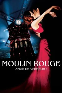 Casal se beija apaixonadamente,mulher em longo vestido vermelho. Ao fundo,moinho iluminado em tom avermelhado. Cenário noturno romântico.