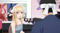 Garota anime loira surpresa com tiara, olhando para homem vendado de costas. Pôsteres de anime no fundo. Clima divertido.