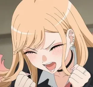 Jovem mulher anime loira com pontas rosa, piercings e choker. Ela sorri extasiada de olhos fechados, punhos cerrados e bochechas coradas.