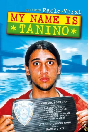 Jovem de olhos arregalados e cabelo escuro segura uma placa policial. Fundo azulado com água e ponte, clima de surpresa e leve confusão.
