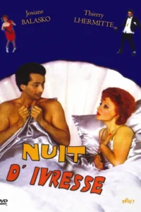 Casal na cama de cetim dentro de uma concha gigante. Ele sem camisa,ela ruiva o observa. Duas figuras flutuam no fundo azul. Clima cômico romântico.