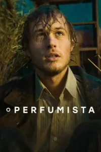 Close-up de um homem jovem,com cabelo molhado e barba,olhando para cima com intensidade. Veste camisa e casaco,em cenário escuro e rústico.
