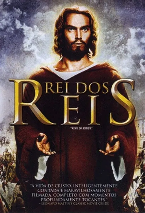 Homem barbudo em túnica e robe, mãos abertas, em destaque. Fundo com céus dramáticos e exércitos antigos.