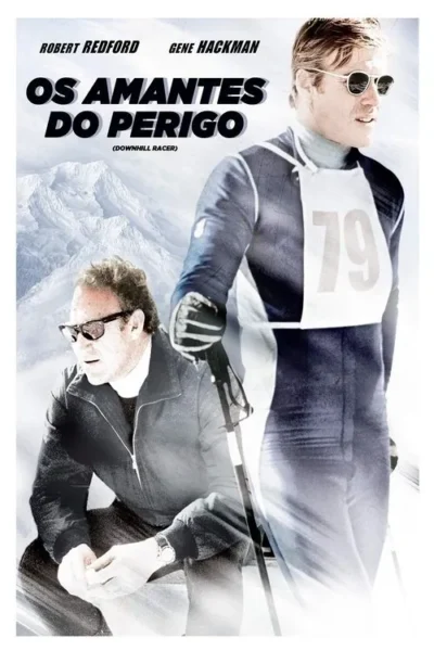 Dois homens em montanhas nevadas. Um esquiador loiro de óculos escuros e uniforme 79. Outro homem agachado, com óculos. Clima de esporte de inverno.