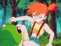 Garota ruiva de top amarelo e shorts se encolhe, com raiva, de uma lagarta verde gigante numa floresta.