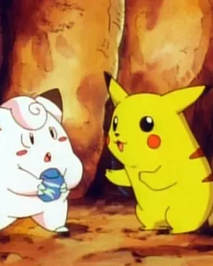 Duas criaturas animadas interagem numa caverna. Uma rosa-claro segura um item, a outra, amarela com cauda de raio, gesticula.