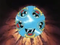 Criaturas azuis, semelhantes a tartarugas, com uma de óculos de sol, espiam curiosas de uma abertura rochosa e escura.